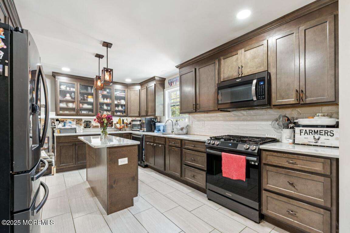 9 Cove Court Howell, NJ 07731 - Photo 8 of 20 a kitchen with stainless steel appliances granite countertop a stove a sink and a microwave