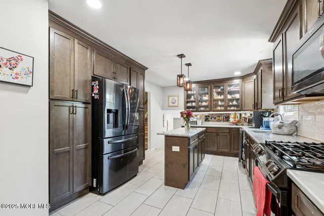 a kitchen with stainless steel appliances granite countertop a refrigerator a stove and a sink