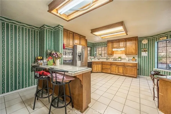 a kitchen with stainless steel appliances kitchen island granite countertop a stove a sink and a refrigerator