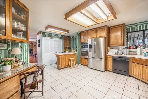 a kitchen with granite countertop a refrigerator and a stove top oven