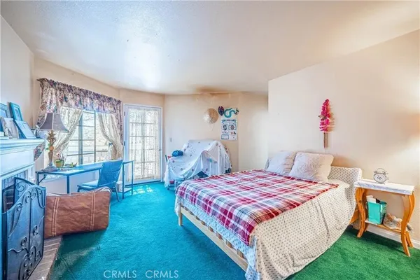 a bedroom with a bed and a dresser next to a window