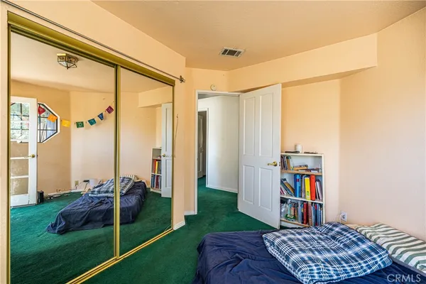 a bedroom with a bed and a bookshelf with wooden floor