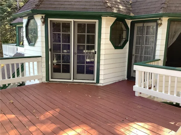 a view of a balcony with wooden floor and outdoor seating