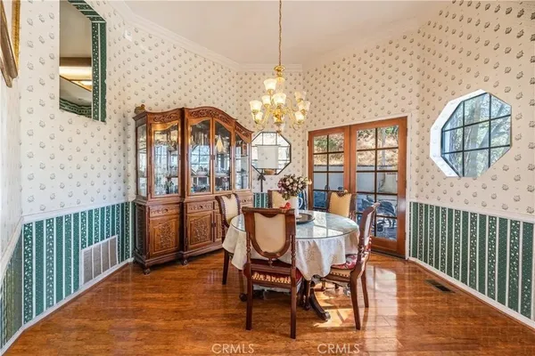 a dining room with furniture a chandelier and wooden floor