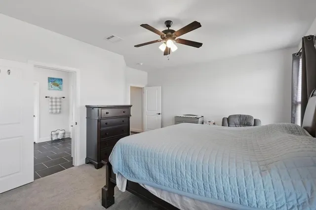 a bedroom with a bed and a ceiling fan