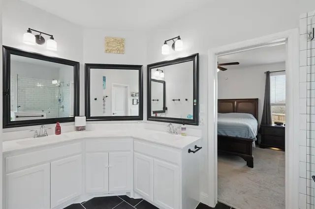 a en suite bathroom with a double vanity sink and a mirror