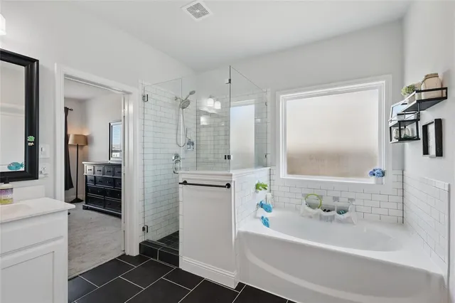 a bathroom with a bathtub a sink a vanity and a shower