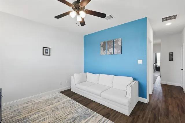 a living room with furniture and a wooden floor