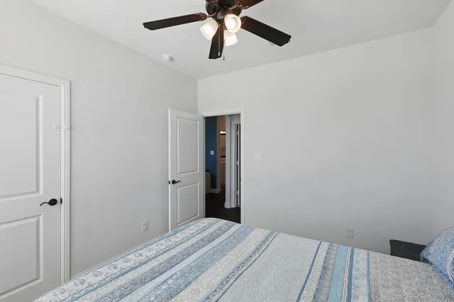 a bedroom with a bed and a chandelier fan