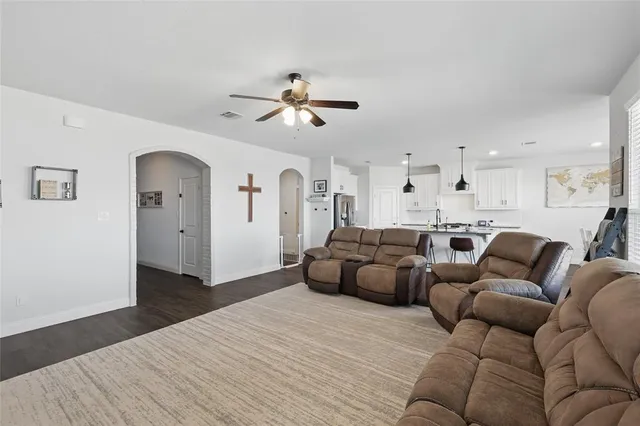 a living room with furniture white walls and wooden floor
