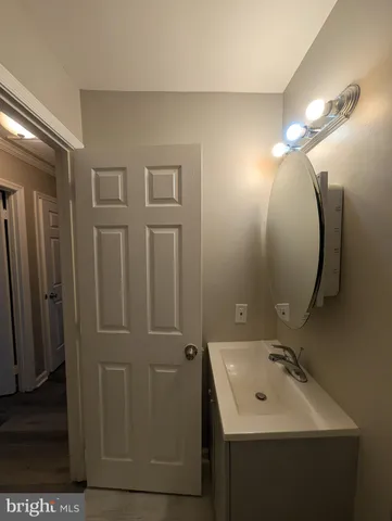 an empty room with wooden floor and bathroom