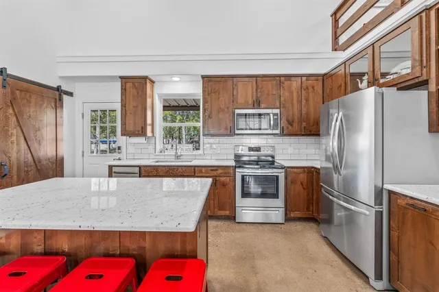 a kitchen with stainless steel appliances granite countertop a refrigerator sink and stove