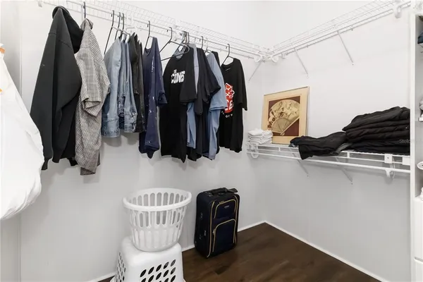 a view of walk in closet with clothes and shoes