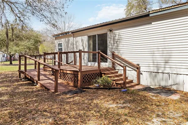 a view of wooden house with a small yard