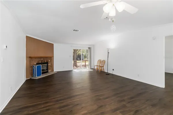 a view of a livingroom with wooden floor and a ceiling fan