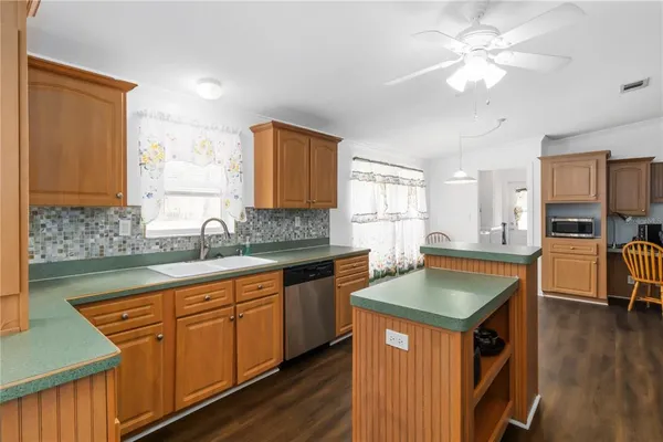 a kitchen with stainless steel appliances granite countertop a sink dishwasher stove and refrigerator with wooden floor
