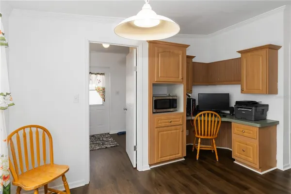 a kitchen with granite countertop a dining table chairs and a refrigerator
