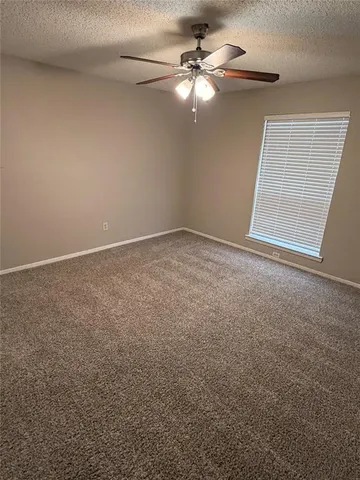 a view of an empty room with a chandelier fan