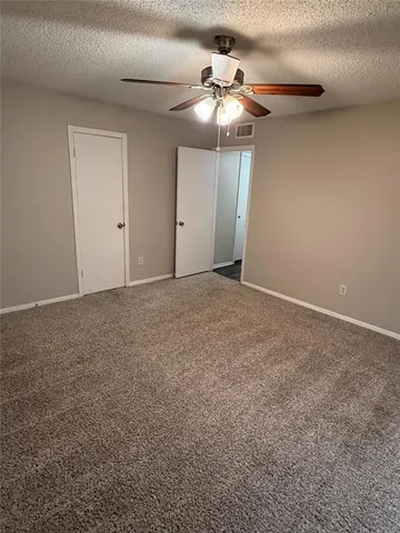 a view of an empty room with a chandelier fan