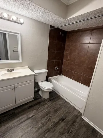 a bathroom with a sink a toilet a mirror and bathtub