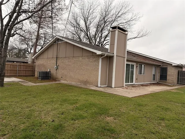 a front view of house with yard and trees in the background
