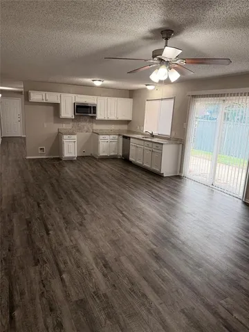 a large kitchen with stainless steel appliances granite countertop a lot of counter space and wooden floor