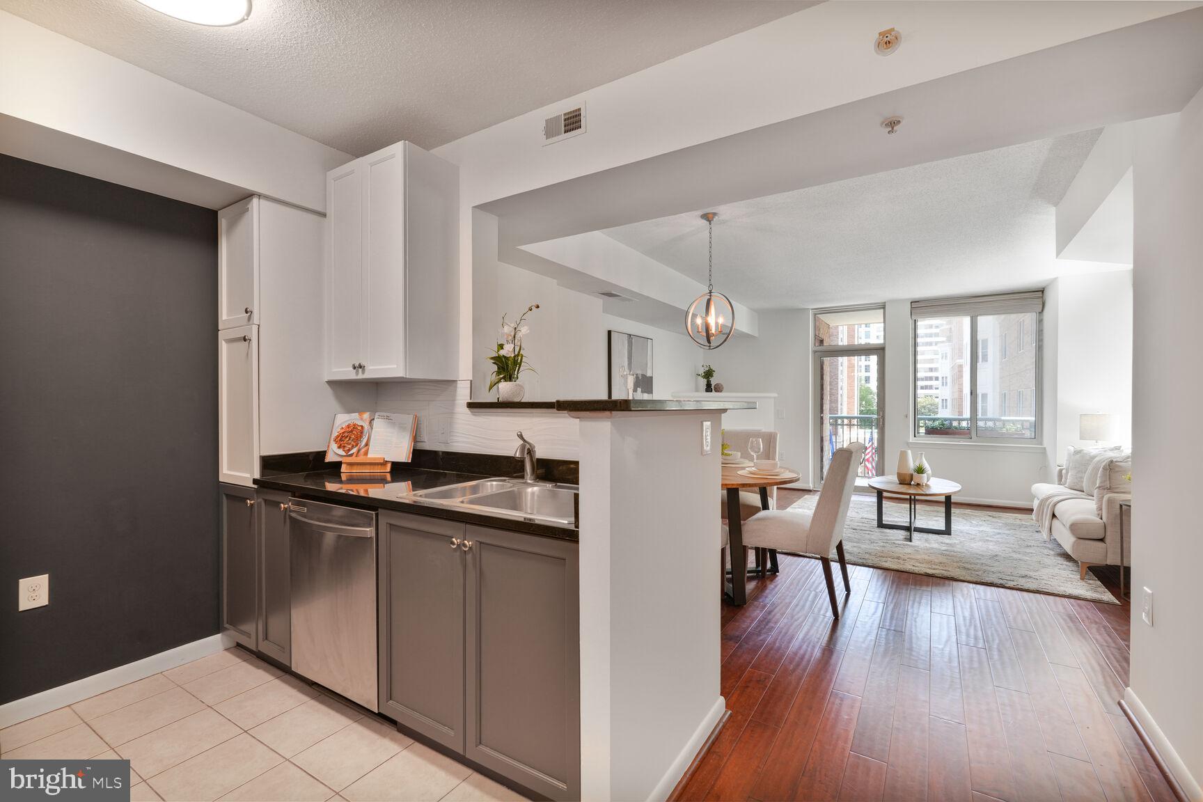 851 North Glebe Road, Unit 409 Arlington, VA 22203 - Photo 10 of 26 a kitchen with a table chairs refrigerator and cabinets