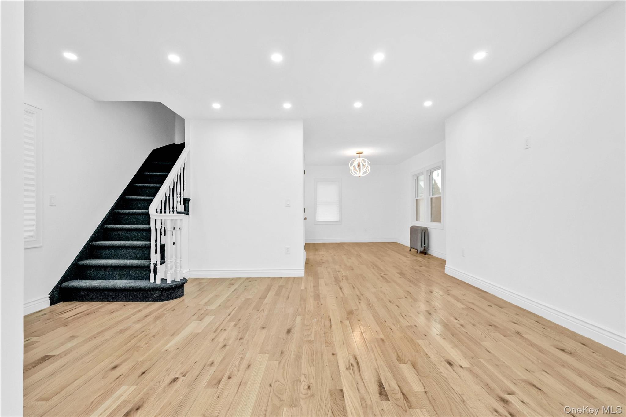 21432 112th Road Queens, NY 11429 - Photo 6 of 18 Unfurnished living room with recessed lighting, light wood-style flooring, stairway, and radiator heating unit