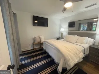 a bedroom with bed and flat screen tv