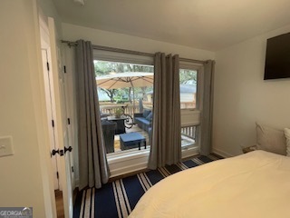 620 Executive Golf Villas Road St. Simons, GA 31522 - Photo 10 of 23 a bedroom with a bed and a flat tv screen next to a window