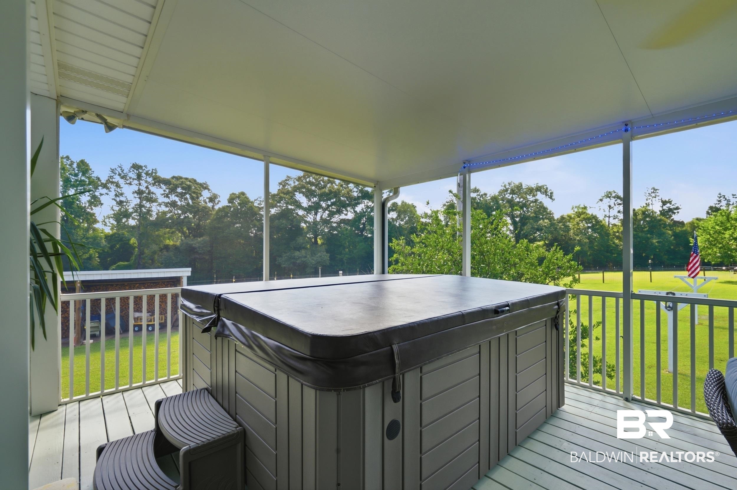15855 Calvin Richerson Road Bay Minette, AL 36507 - Photo 16 of 83 Screened porch featuring a hot tub with cover, composite steps, and a painted wood-finish floor