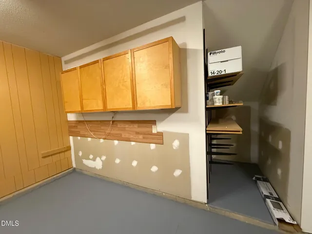 a view of walk in closet with clothes and window