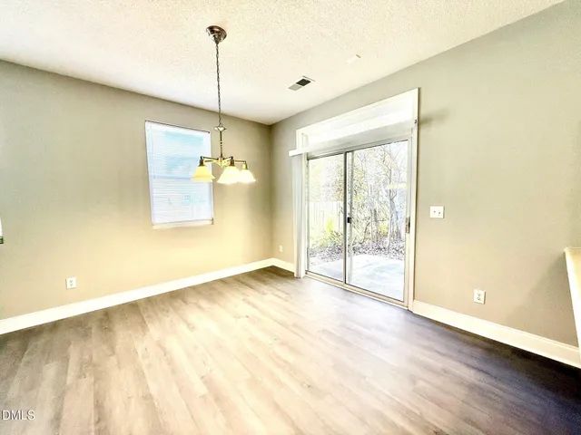 a view of a room with wooden floor and a chandelier