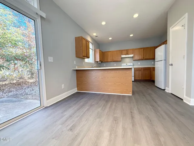 a view of kitchen with wooden floor and electronic appliances