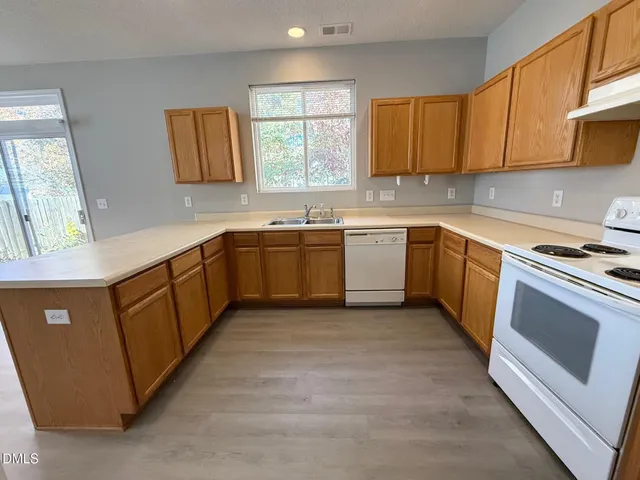 a kitchen with sink stove and cabinets