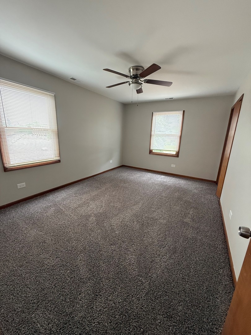 674 East Algonquin Road Des Plaines, IL 60016 - Photo 13 of 19 an empty room with a ceiling fan and a window