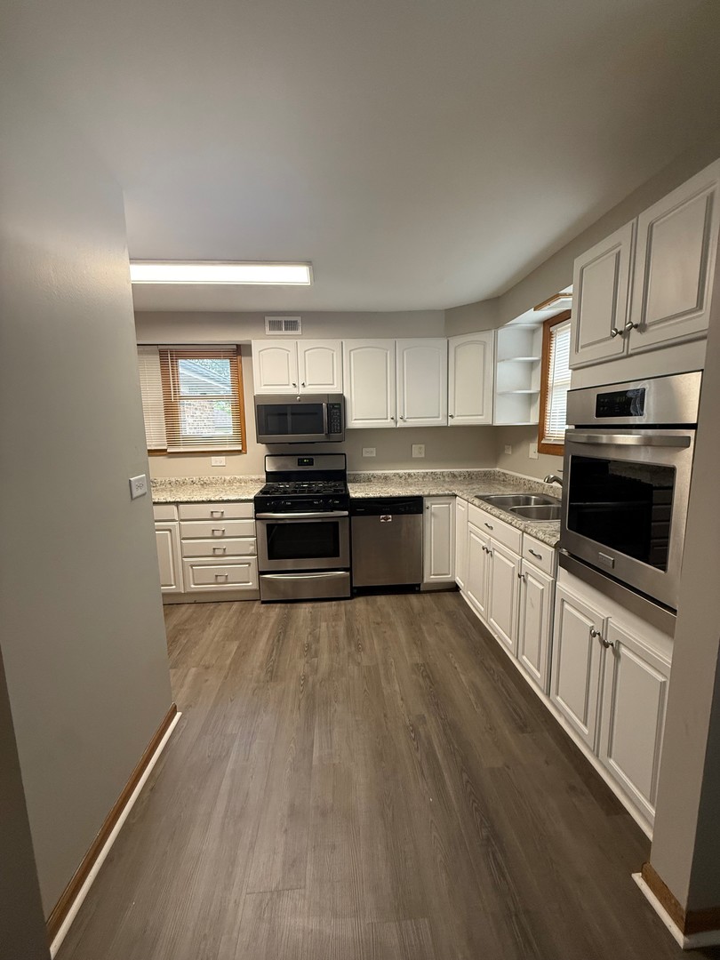 674 East Algonquin Road Des Plaines, IL 60016 - Photo 7 of 19 a kitchen with granite countertop a refrigerator and a stove top oven