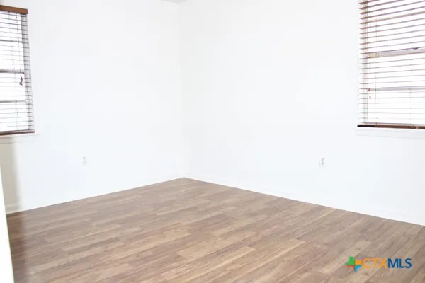 a view of empty room with wooden floor