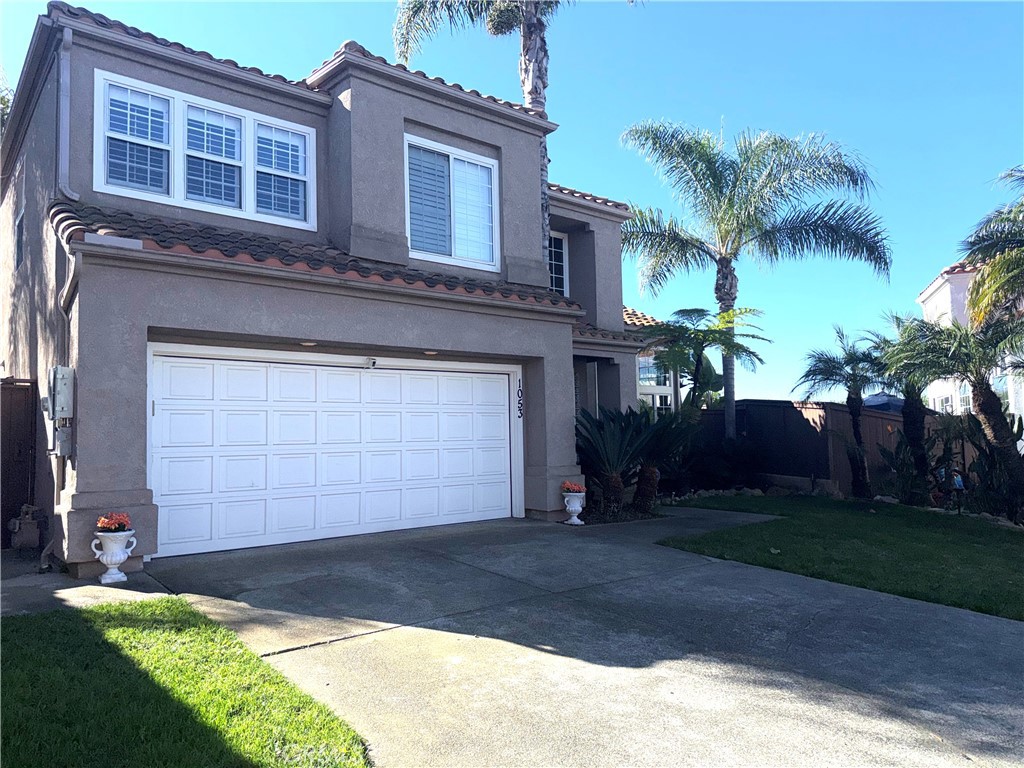 1053 Regatta Costa Mesa, CA 92627 - Photo 2 of 24 a front view of a house with a yard and garage
