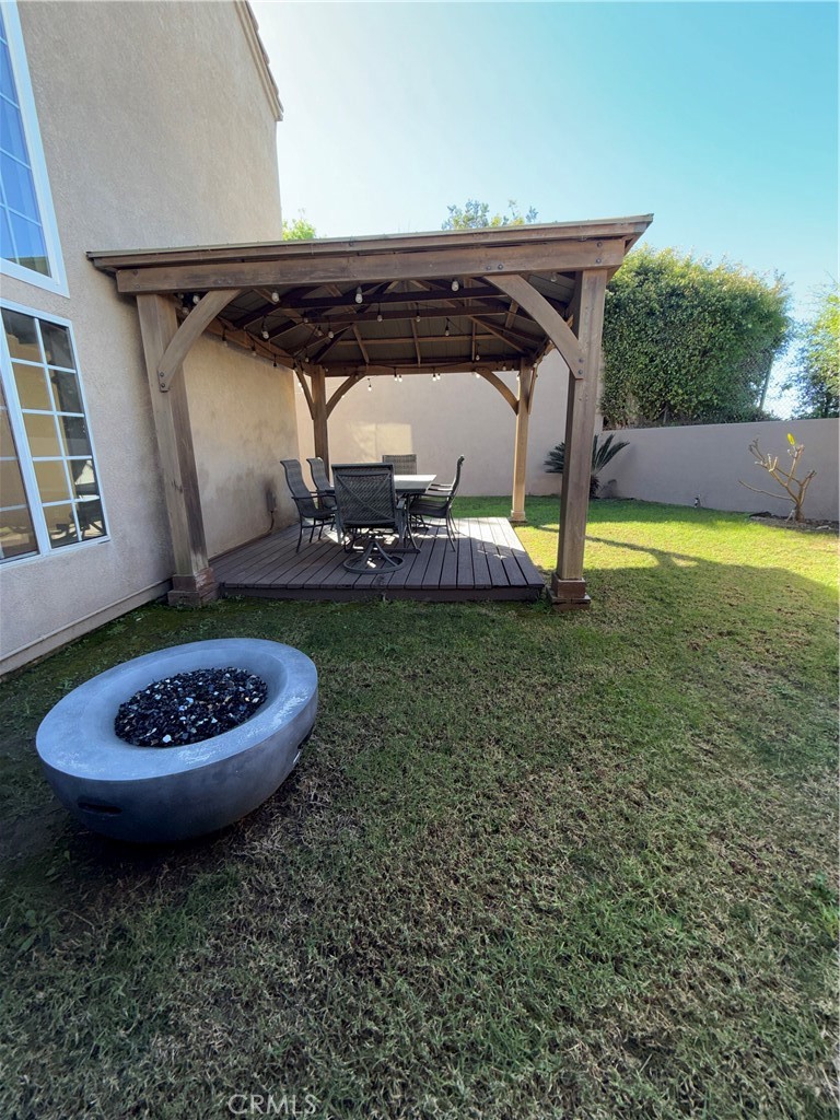 1053 Regatta Costa Mesa, CA 92627 - Photo 22 of 24 a view of a backyard with table and chairs with wooden floor and fence