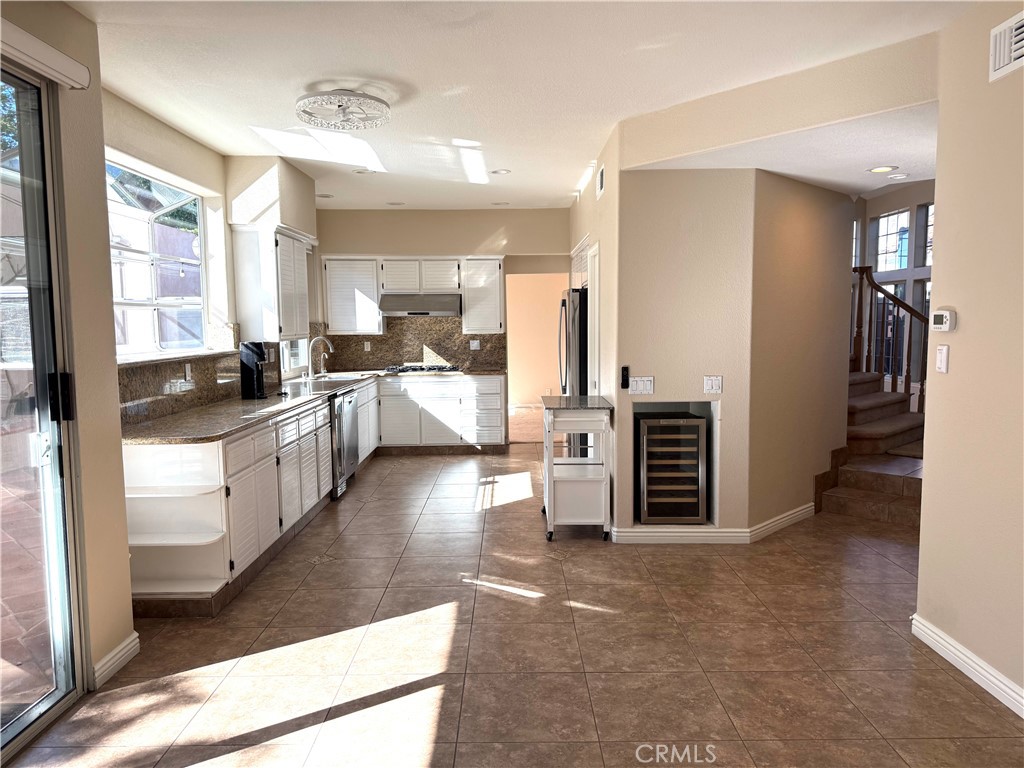 1053 Regatta Costa Mesa, CA 92627 - Photo 8 of 24 a kitchen with stainless steel appliances a stove a sink a refrigerator and a cabinets