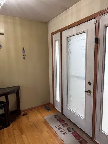 a view of hallway with closet and wooden floor