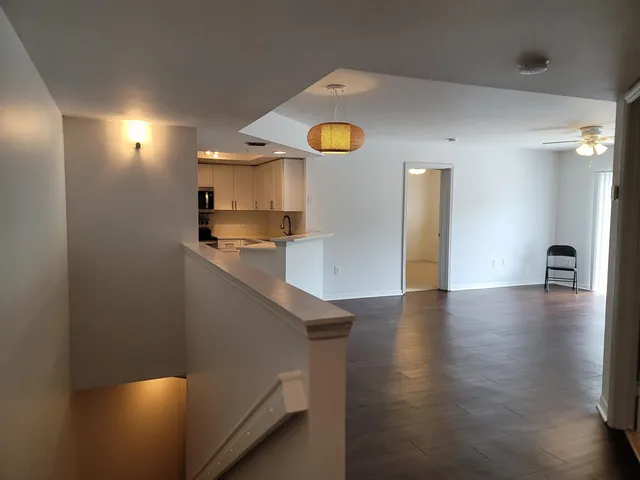 a kitchen with stainless steel appliances granite countertop a refrigerator a stove and a wooden floor