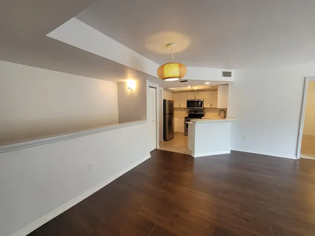 a view of a kitchen with a sink and a refrigerator