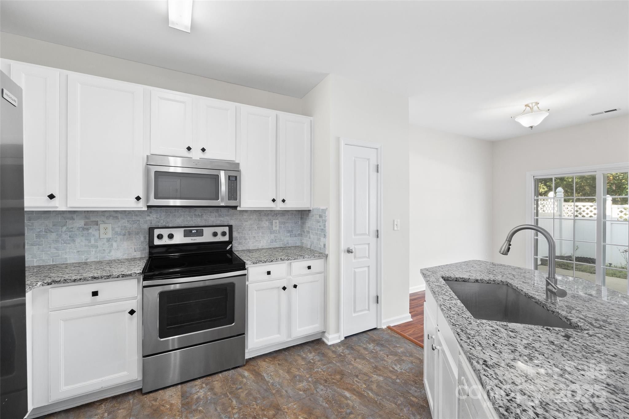 975 Copperstone Lane Fort Mill, SC 29708 - Photo 14 of 35 a kitchen with granite countertop a sink a stove and cabinets