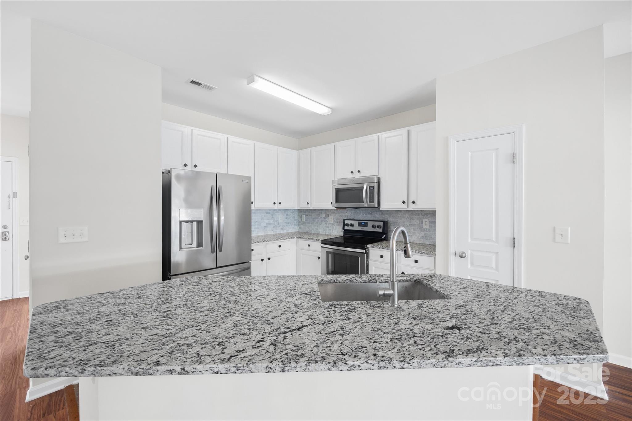 975 Copperstone Lane Fort Mill, SC 29708 - Photo 15 of 35 a kitchen with stainless steel appliances kitchen island granite countertop a sink refrigerator and microwave
