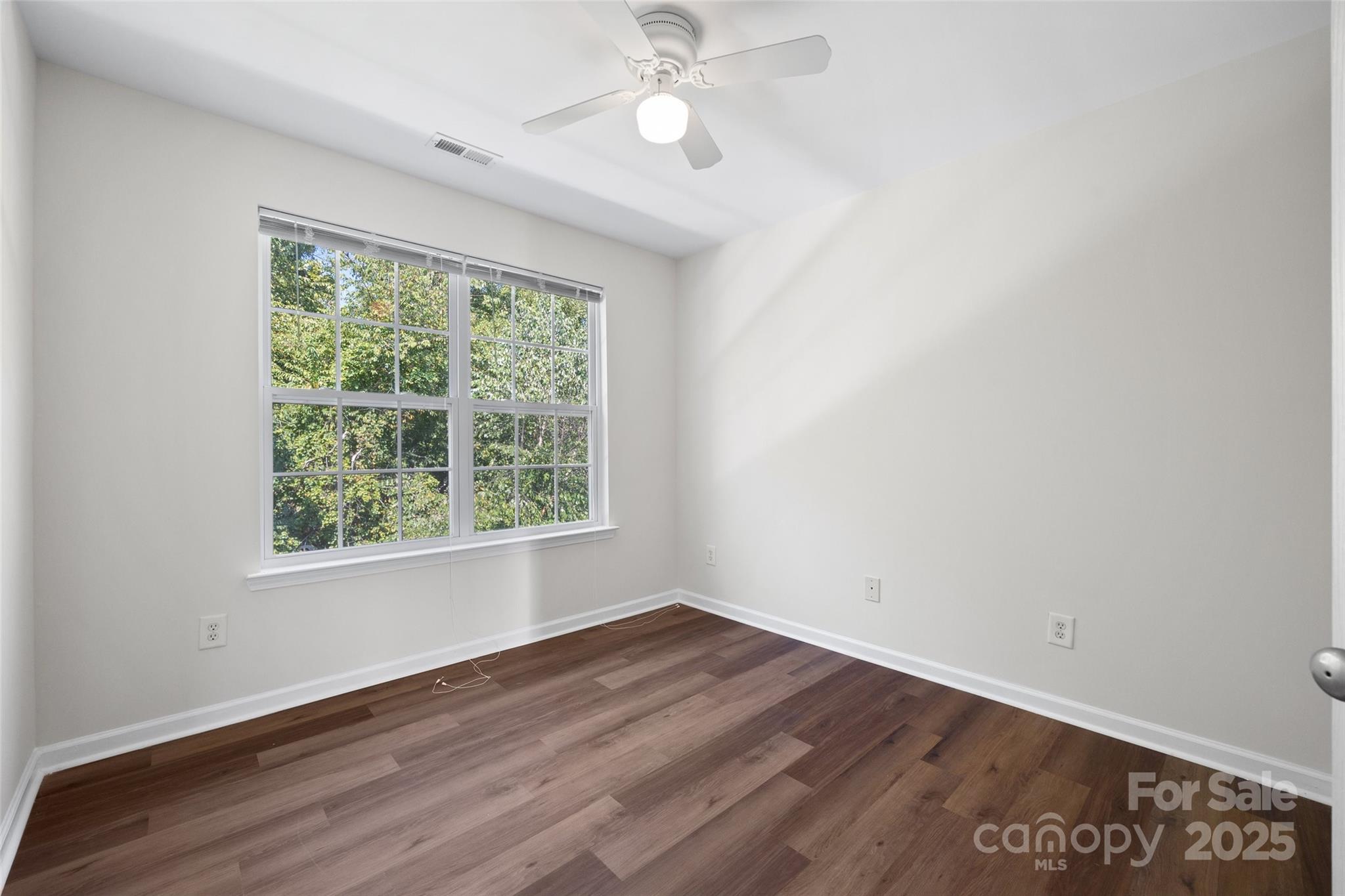 975 Copperstone Lane Fort Mill, SC 29708 - Photo 17 of 35 an empty room with wooden floor ceiling fan and windows