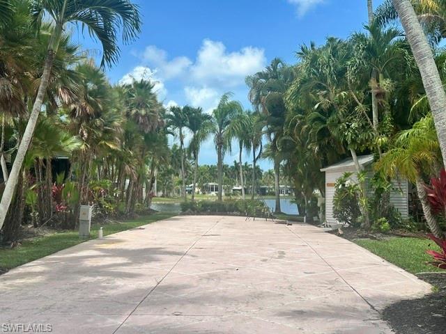 1404 Pearl Lake Point Naples, FL 34114 - Photo 4 of 9 a backyard of a house with palm trees