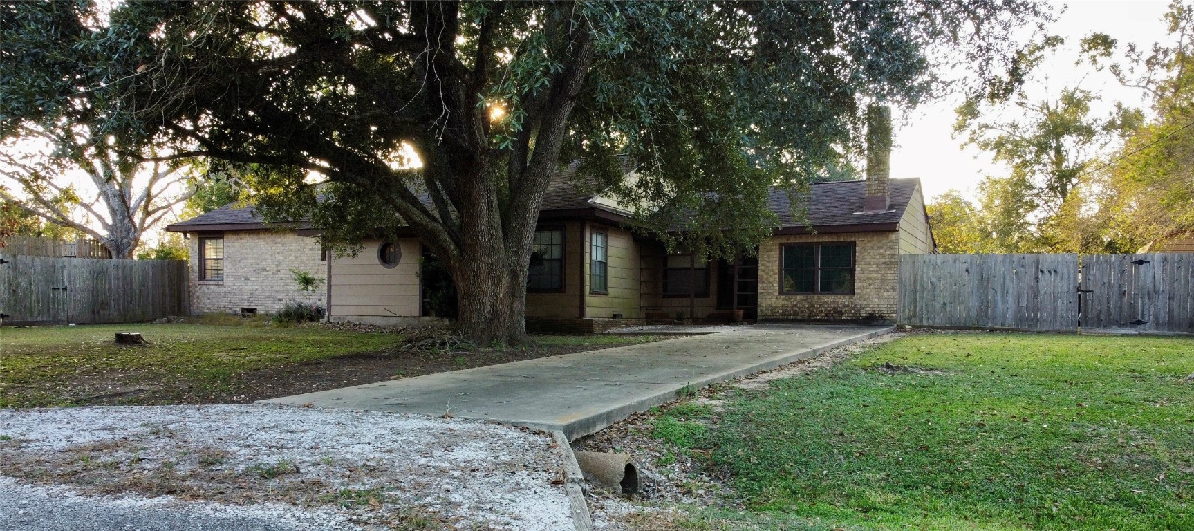 a front view of a house with a yard and tree