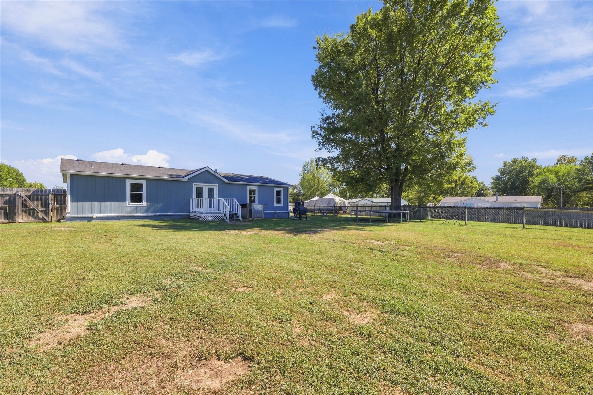 15 Sun Prairie Road Pryor, OK 74361 - Photo 21 of 34 Expansive rear lawn with perimeter fencing, a mature shade tree, and a back deck